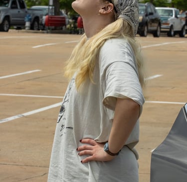 Abigail Bolton, 19, stand in the 85C Bakery Cafe parking lot to watch the solar eclipse. Photo by Taylor Pleasant