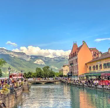 an image of colorful houses by the river overlooking a green mountain