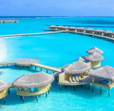 a beach resort with a pier and a dock, and floating villas in Maldives