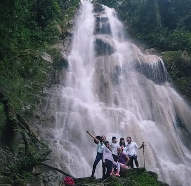 a group of people standing around a waterfall