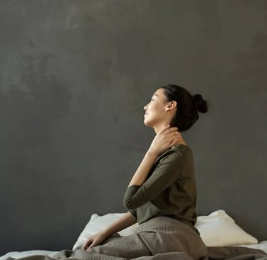 a woman sitting on a bed with a blanket on it