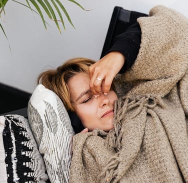 a woman in a blanket on a couch