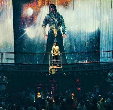 a man standing on a stage with a giant painting of a man on a stage cocobongo punta cana
