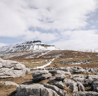 Distant view of Pen-y-ghent peak with snow covering the summit in the Yorkshire Dales, England
