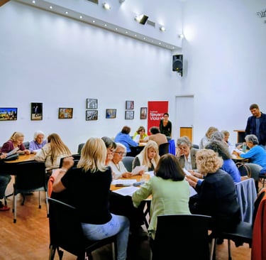 Profesional coordinando una actividad de estimulación cognitiva grupal con personas mayores en un ge