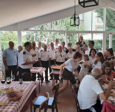 a group of people sitting at a table with food