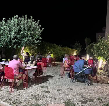 a group of people sitting at tables outside