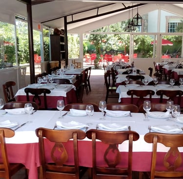 a restaurant with tables and chairs and a table with plates and glasses
