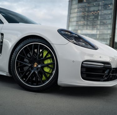an Enlab white porsche panamera parked on a city street