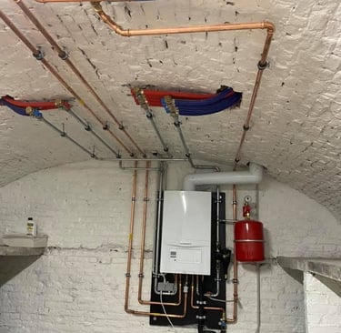 Technische ruimte met verwarmingsketel en verdelers, geïnstalleerd door AP Services in Leuven