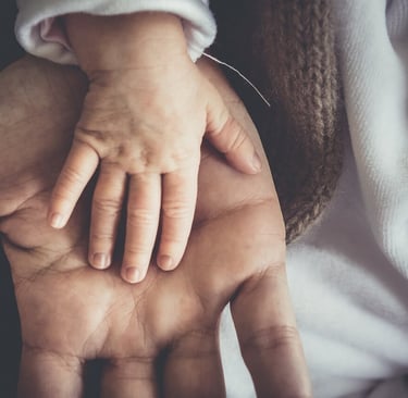 Une main de bébé dans une main d'adulte