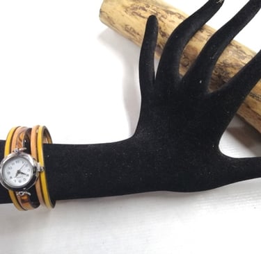 a wrist watch with a wooden bracelet and a watch on it