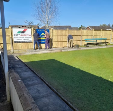Members replace the sponsors signs on our new fence