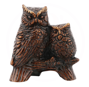 a pair of brass owls sitting on a tree branch