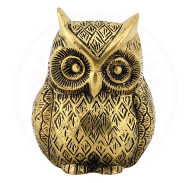 a gold owl figurine with a black and white background