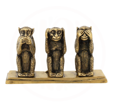 three wise monkeys sitting on a wooden block