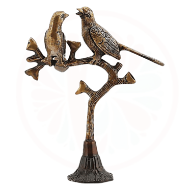 a bronze bird on a tree branch with a bird on it