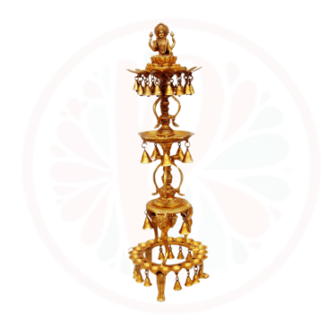 a tall gold candle holder with bells and bells