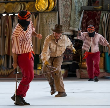 a man in a hat swinging a whip
