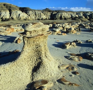 a rock formation in the desert with a blue sky