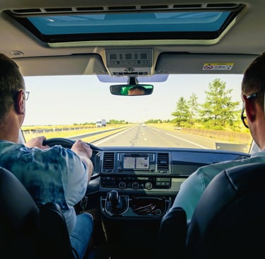 two men driving a car on a highway
