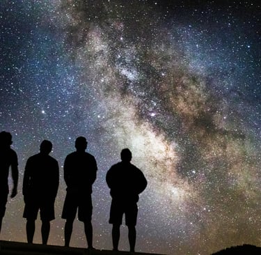 four people standing looking at the stars