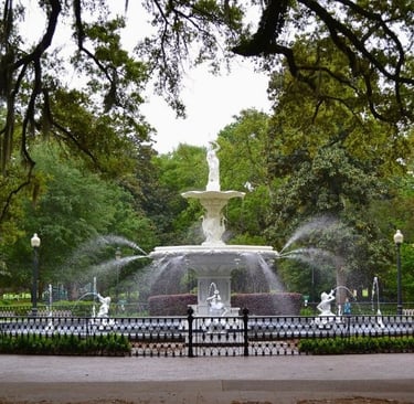 a fountain with a statue of a man in the foreground