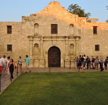 a group of people standing in front of alamo