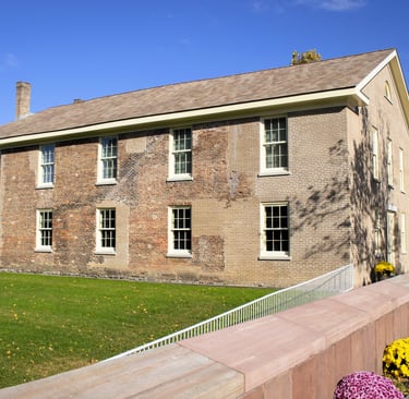 a brick building with a fenced in area with flowers