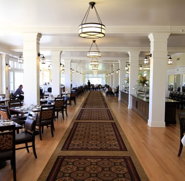 a long room with chairs and tables in a restaurant