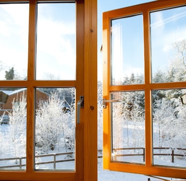 fenêtre en bois donnant sur un extérieur enneigée