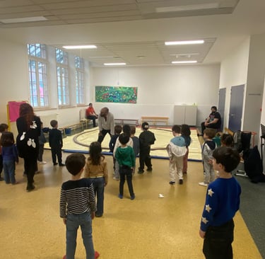 Des enfants font face a un homme placé qui s'adressent a eux, devant un dohyo