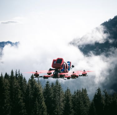 fpv drone strapped with a gopro and red propellers flying over a mountain range