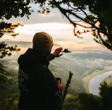 a person standing on a mountain top with a dji drone in the air
