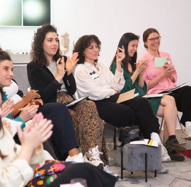 Women applauding for women at public speaking workshop