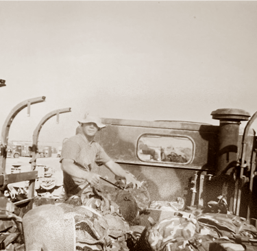 A young Marine preparing his gear in the back of a military transport truck during the 2003 Iraq inv