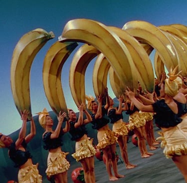 Technicolor chorus girls holding oversized bananas in arch formation from The Gang’s All Here (1943)