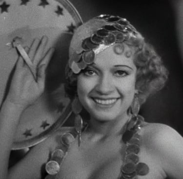 Chorus girl revealing her face from behind a large prop in Busby Berkeley’s classic “parade of faces