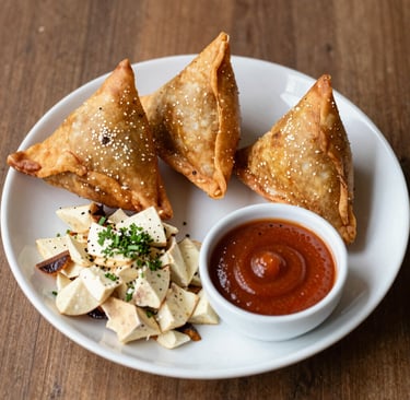 An inviting platter of mixed Indian and Nepali appetizers with pops of green chutney and orange lentil dal.