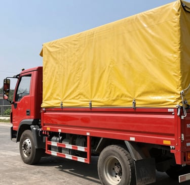 A worker measuring and cutting a roll of blue PVC tarpaulin.