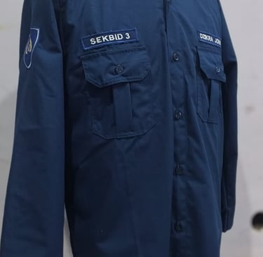 Navy blue custom organizational work shirt on a mannequin with name patches and chest pockets.