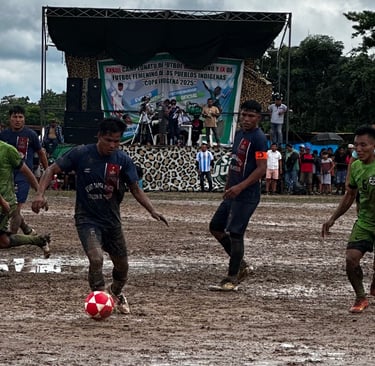 Indigenous soccer tournament players competing on a muddy field during the Copa Indígena 2025.