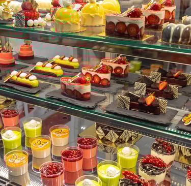 assorted dairy desserts and pastries in display case