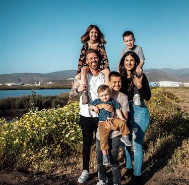 large young caucasian family smiling at sunset by a river in the country