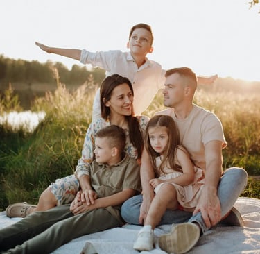 large caucasian family having picnic at sunset