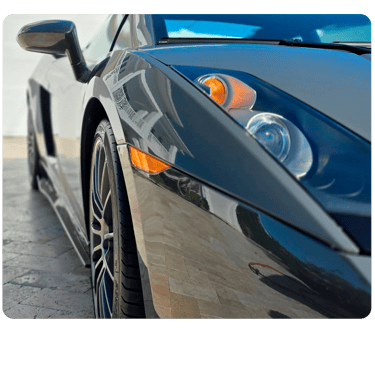 Close-up of a grey Lamborghini Gallardo luxury supercar showing headlight and alloy wheel.