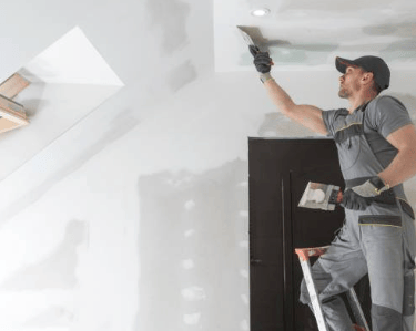taper finishing drywall on the ceiling