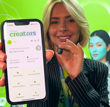 Mulher segurando o celular com o aplicativo YouShop Creator aberto, indicando números de sucesso.