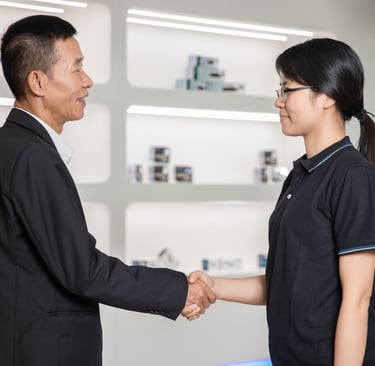 Professional business handshake between a male executive and female colleague in a modern office.