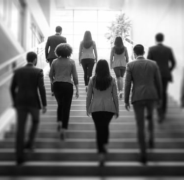 a group of diverse employees climbing a staircase together